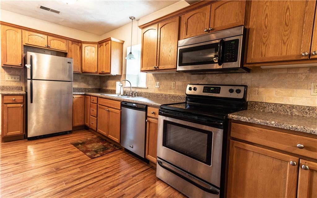 210 Whitestown Road Butler, PA 16001 - Photo 6 of 21 a kitchen with stainless steel appliances granite countertop a stove microwave refrigerator and cabinets