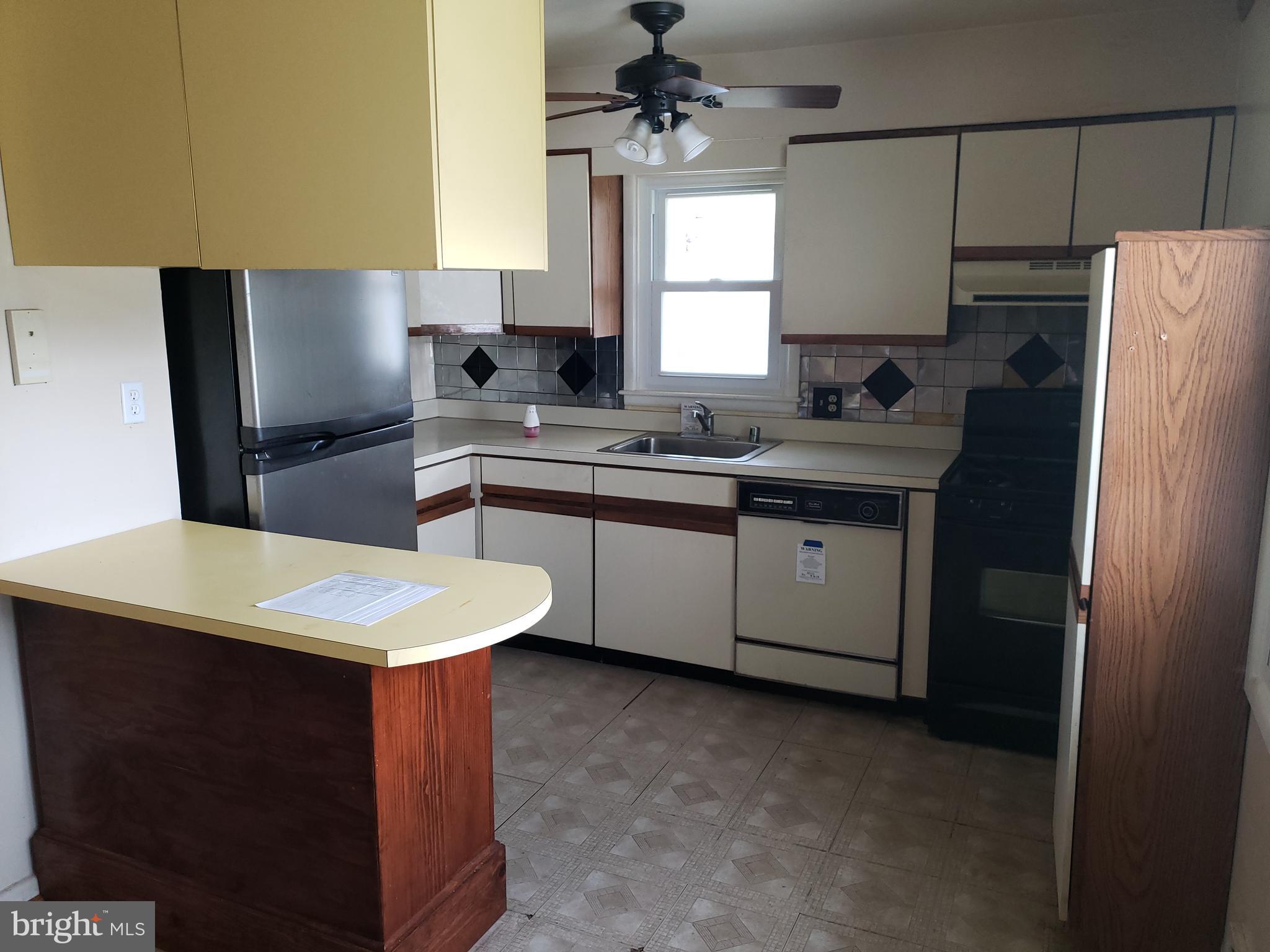 7415 Remoor Road Baltimore, MD 21207 - Photo 12 of 45 a kitchen with stainless steel appliances granite countertop a sink stove a refrigerator a washer dryer and white cabinets