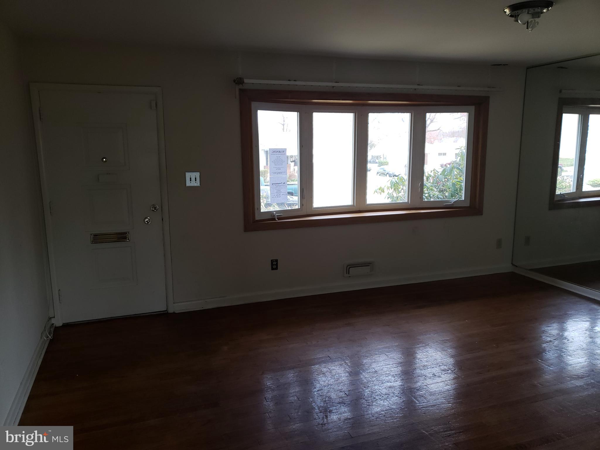 7415 Remoor Road Baltimore, MD 21207 - Photo 19 of 45 a view of an empty room with wooden floor and a window