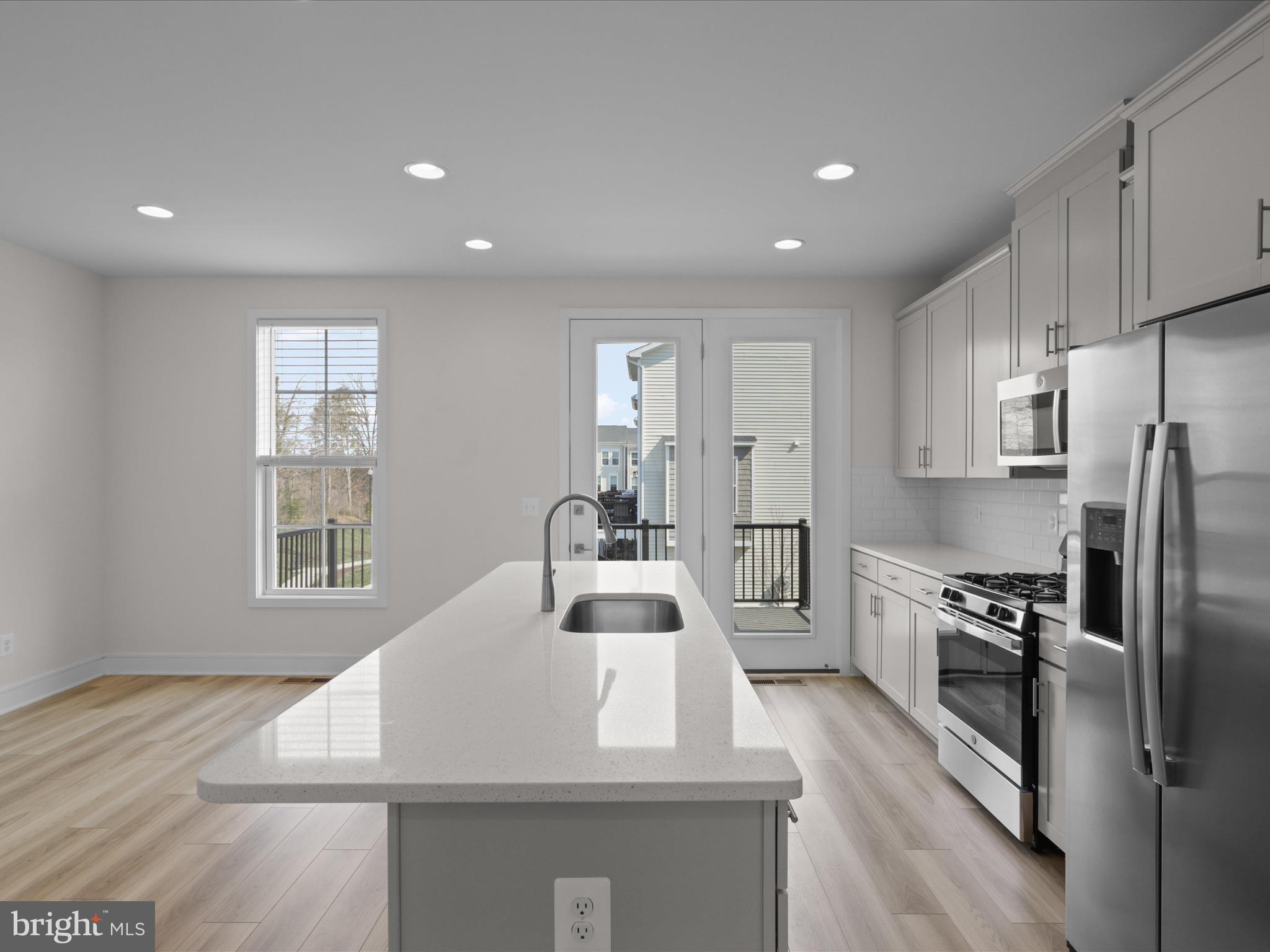 14564 Alsace Lane Gainesville, VA 20155 - Photo 12 of 44 a kitchen with kitchen island a counter top space a sink stainless steel appliances and cabinets