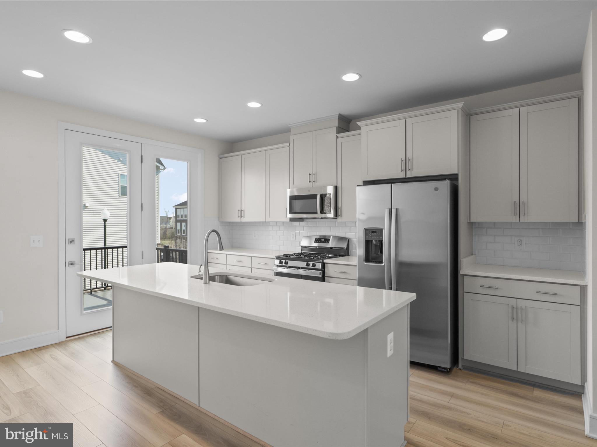 14564 Alsace Lane Gainesville, VA 20155 - Photo 9 of 44 a kitchen with white cabinets and stainless steel appliances