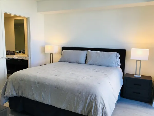 a bedroom with a bed and a lamp