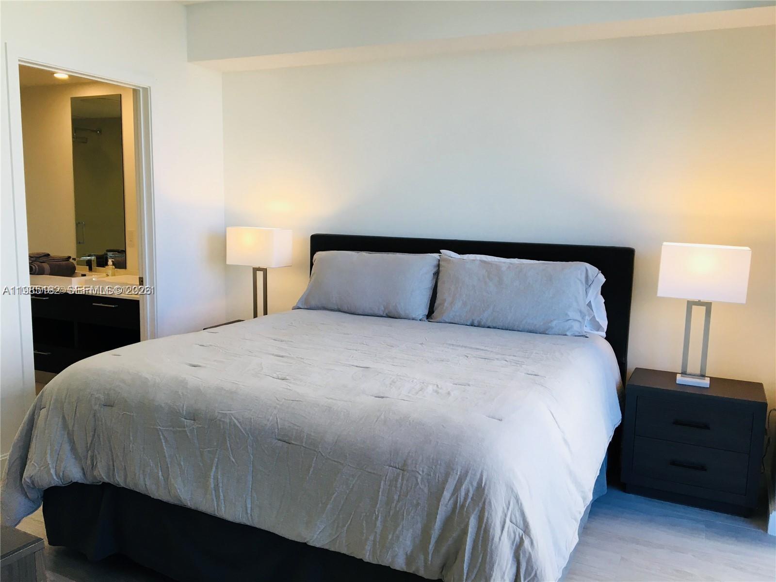 55 Southwest 9th Street, Unit 2901 Miami, FL 33130 - Photo 13 of 20 a bedroom with a bed and a lamp