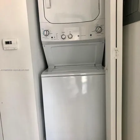 a close up view of a washer dryer with white walls