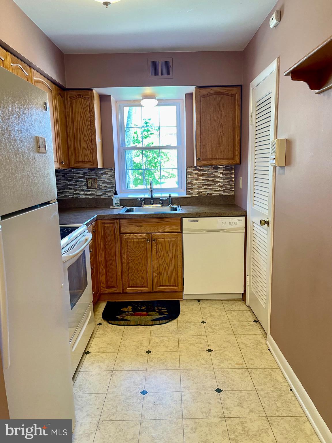 804 South Avenue, Unit D7 Secane, PA 19018 - Photo 14 of 35 a kitchen with a wooden floor and a refrigerator