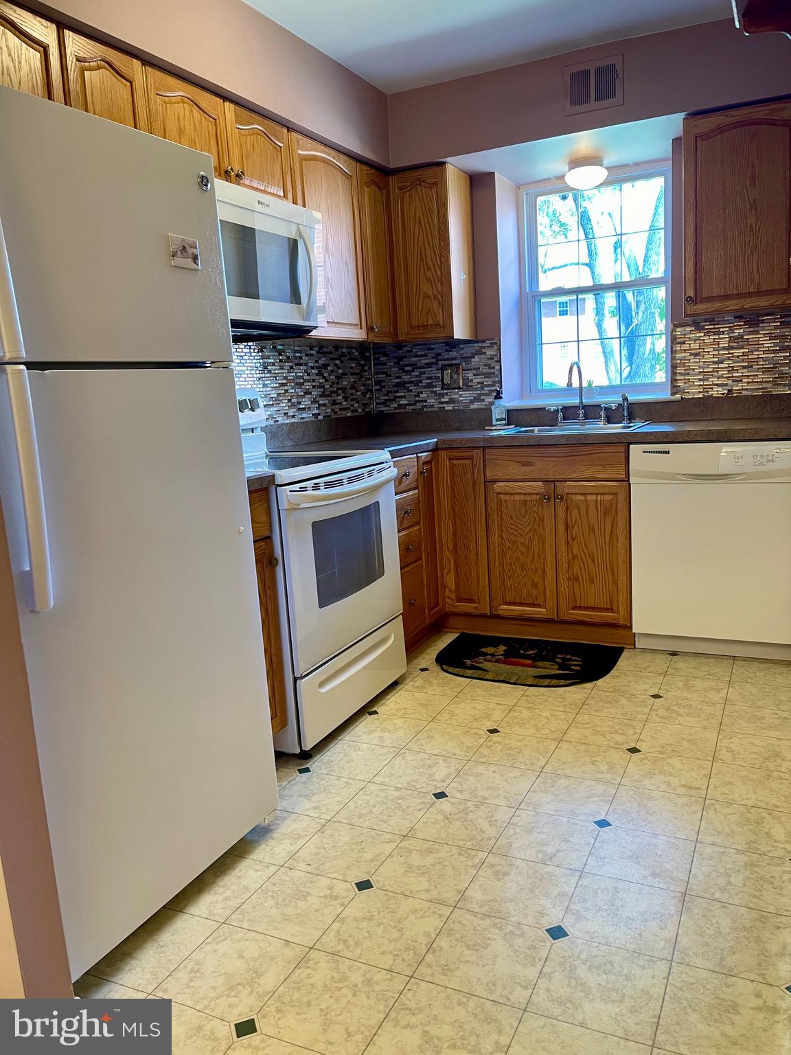 804 South Avenue, Unit D7 Secane, PA 19018 - Photo 15 of 35 a kitchen with granite countertop a stove a sink and a refrigerator