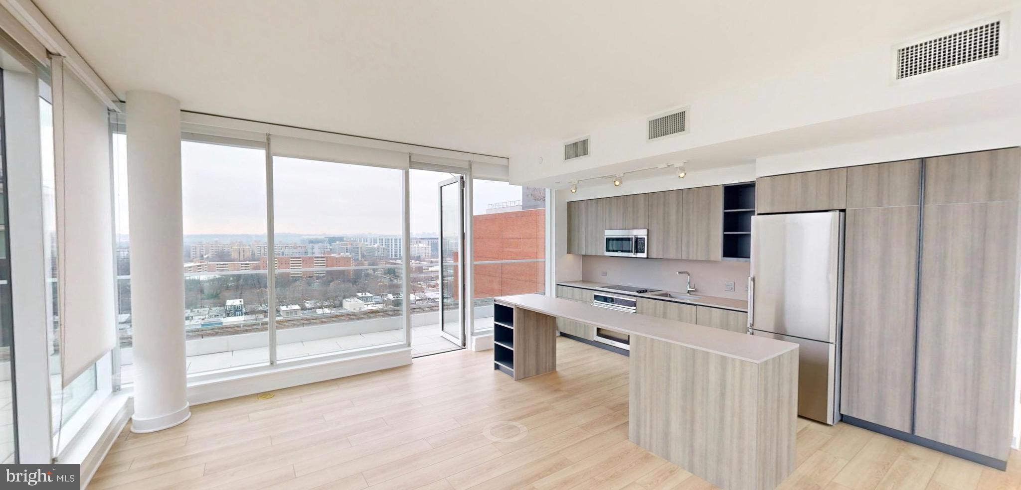 1201 Half Street Southwest, Unit PH1201 Washington, DC 20003 - Photo 2 of 26 a kitchen with stainless steel appliances granite countertop a refrigerator and a stove top oven
