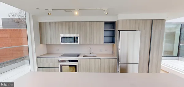 a kitchen with a refrigerator and a stove top oven