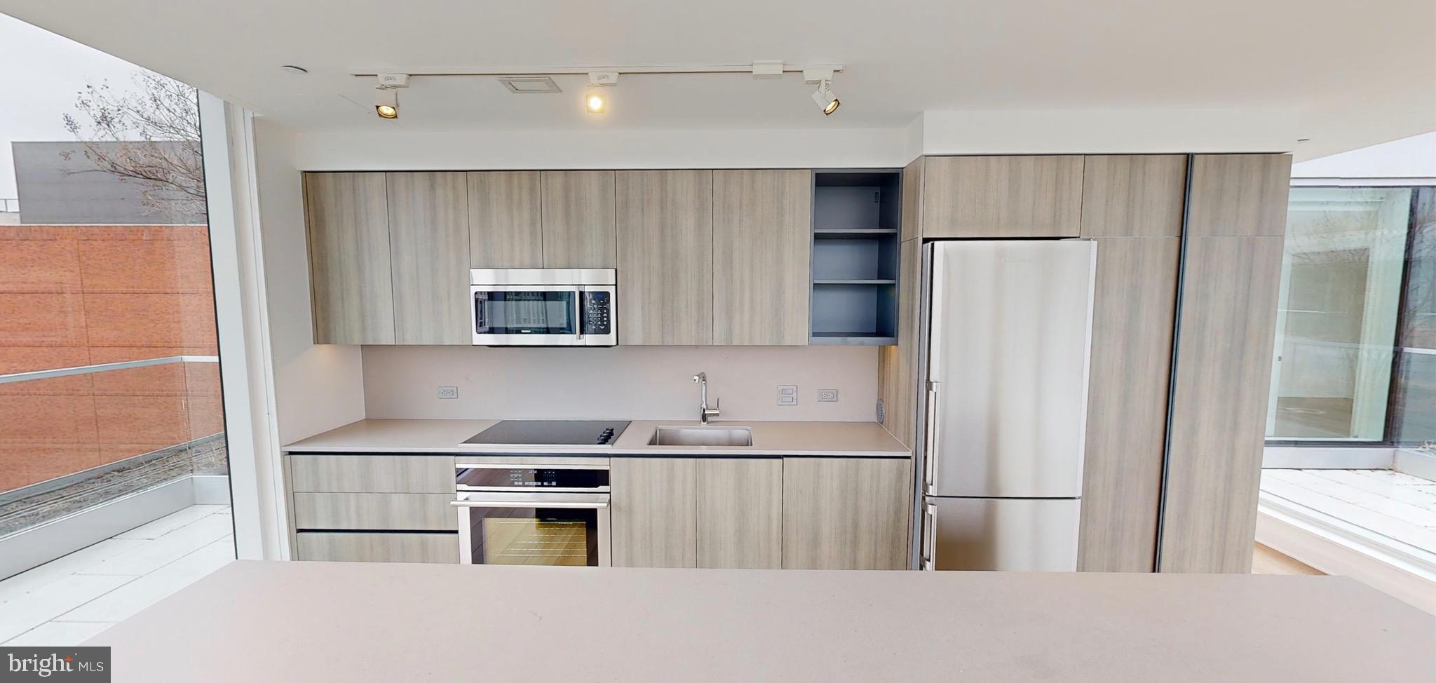 1201 Half Street Southwest, Unit PH1201 Washington, DC 20003 - Photo 5 of 26 a kitchen with a refrigerator and a stove top oven