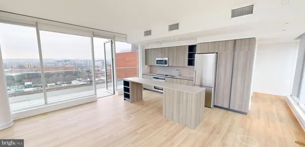 a open kitchen with stainless steel appliances a stove top oven a refrigerator a sink with a dining table and chairs