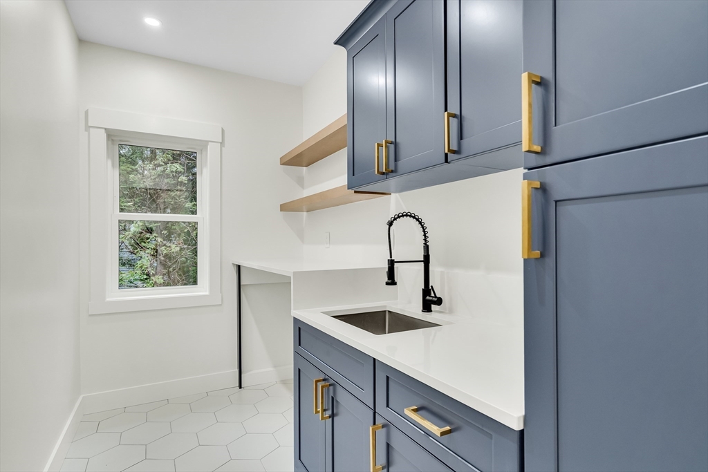22 Estabrook Road Lexington, MA 02421 - Photo 31 of 35 a kitchen with a sink a faucet a window and stainless steel appliances