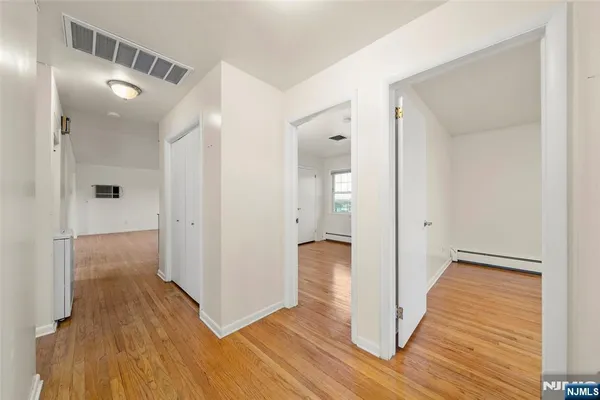 a view of a hallway with wooden floor