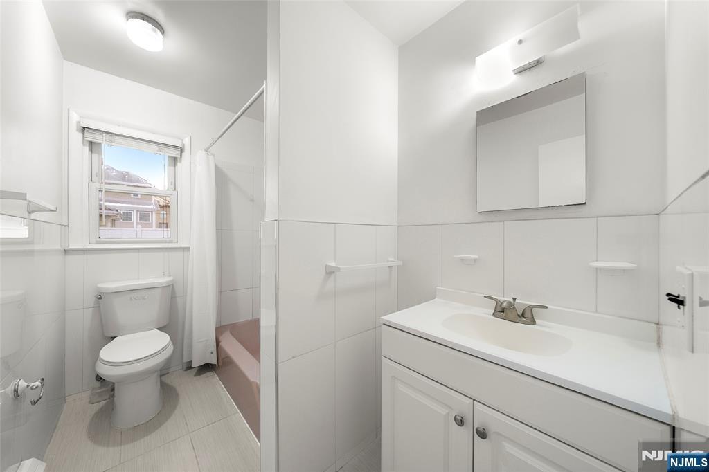 410 Mayer Court Ridgefield, NJ 07657 - Photo 19 of 22 a bathroom with a sink a toilet and a mirror