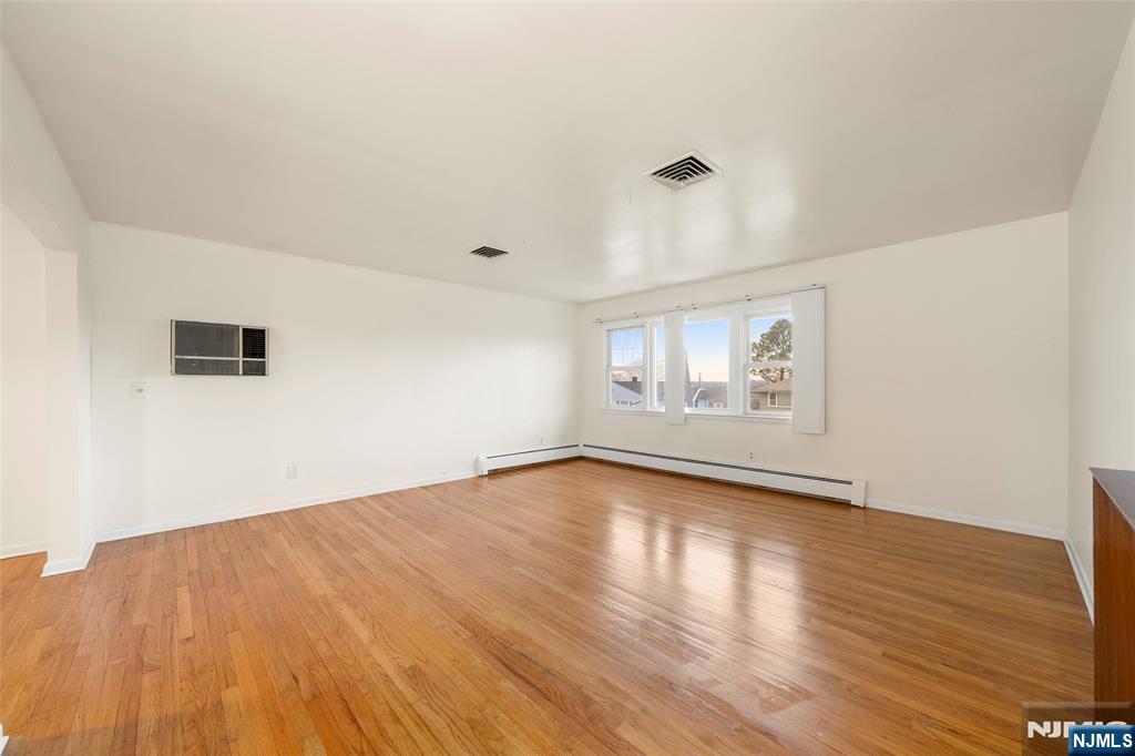 410 Mayer Court Ridgefield, NJ 07657 - Photo 2 of 22 an empty room with wooden floor and windows