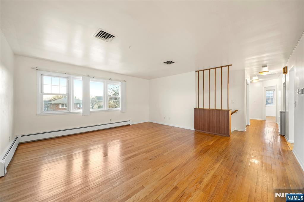 410 Mayer Court Ridgefield, NJ 07657 - Photo 3 of 22 wooden floor in an empty room with a window