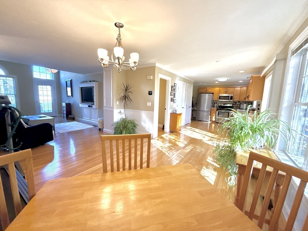 63 Providence Road, Unit 2 Grafton, MA 01519 - Photo 4 of 9 a view of a dining room with furniture a chandelier and wooden floor