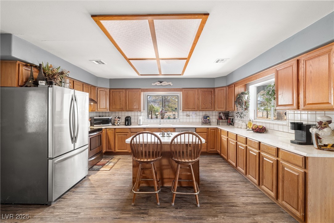 3951 West Blosser Ranch Road Pahrump, NV 89060 - Photo 11 of 35 Kitchen with stainless steel appliances, tasteful backsplash, light countertops, and wood finished floors