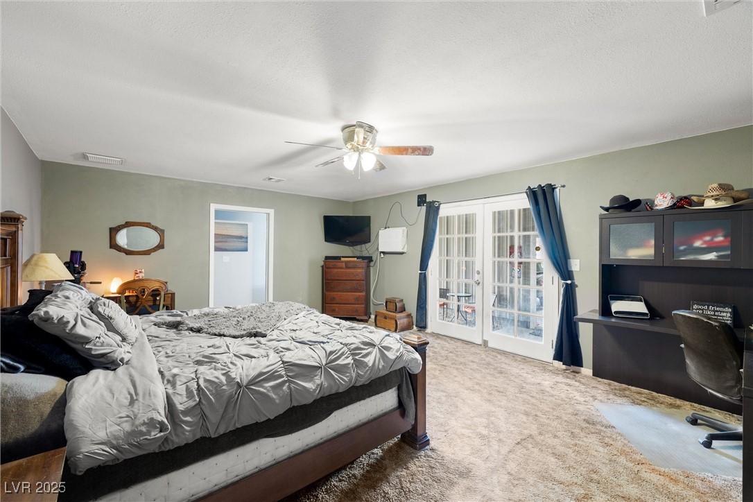 3951 West Blosser Ranch Road Pahrump, NV 89060 - Photo 21 of 35 Bedroom featuring carpet floors, an office area, a ceiling fan, access to outside, and french doors