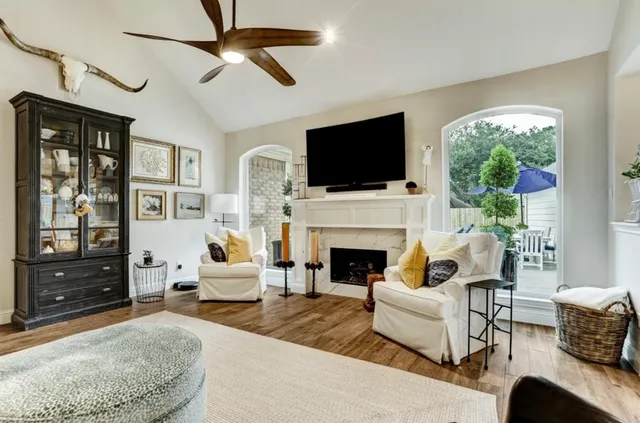 a living room with furniture a flat screen tv and a fireplace