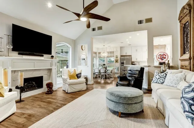 a living room with furniture a flat screen tv and a fireplace