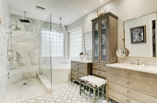 a bathroom with a double vanity sink mirror and bathtub