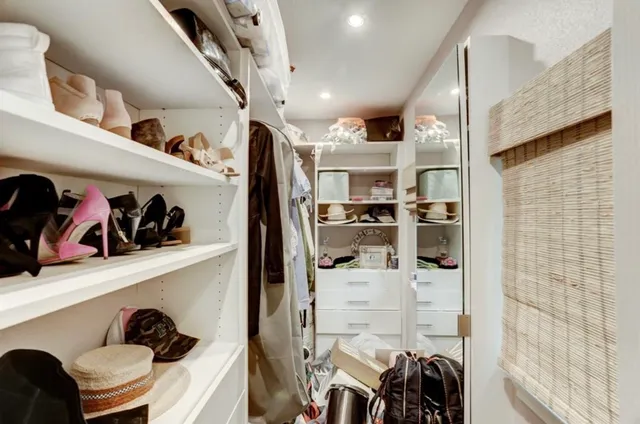a view of walk in closet with clothes and shoes