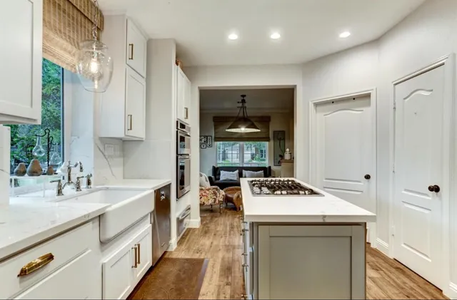 a kitchen that has a sink a stove and chairs
