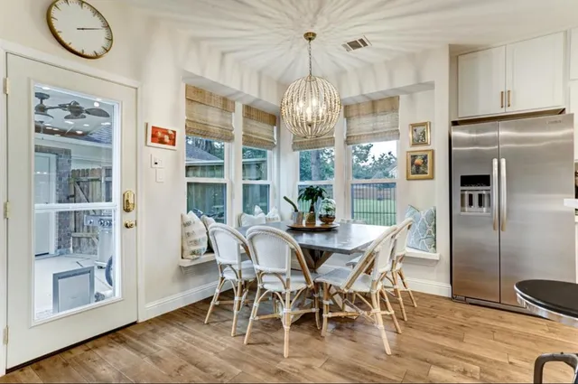 a view of a dining room with furniture a chandelier and wooden floor