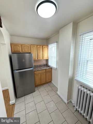 a kitchen with granite countertop a refrigerator a sink a stove a microwave and cabinets