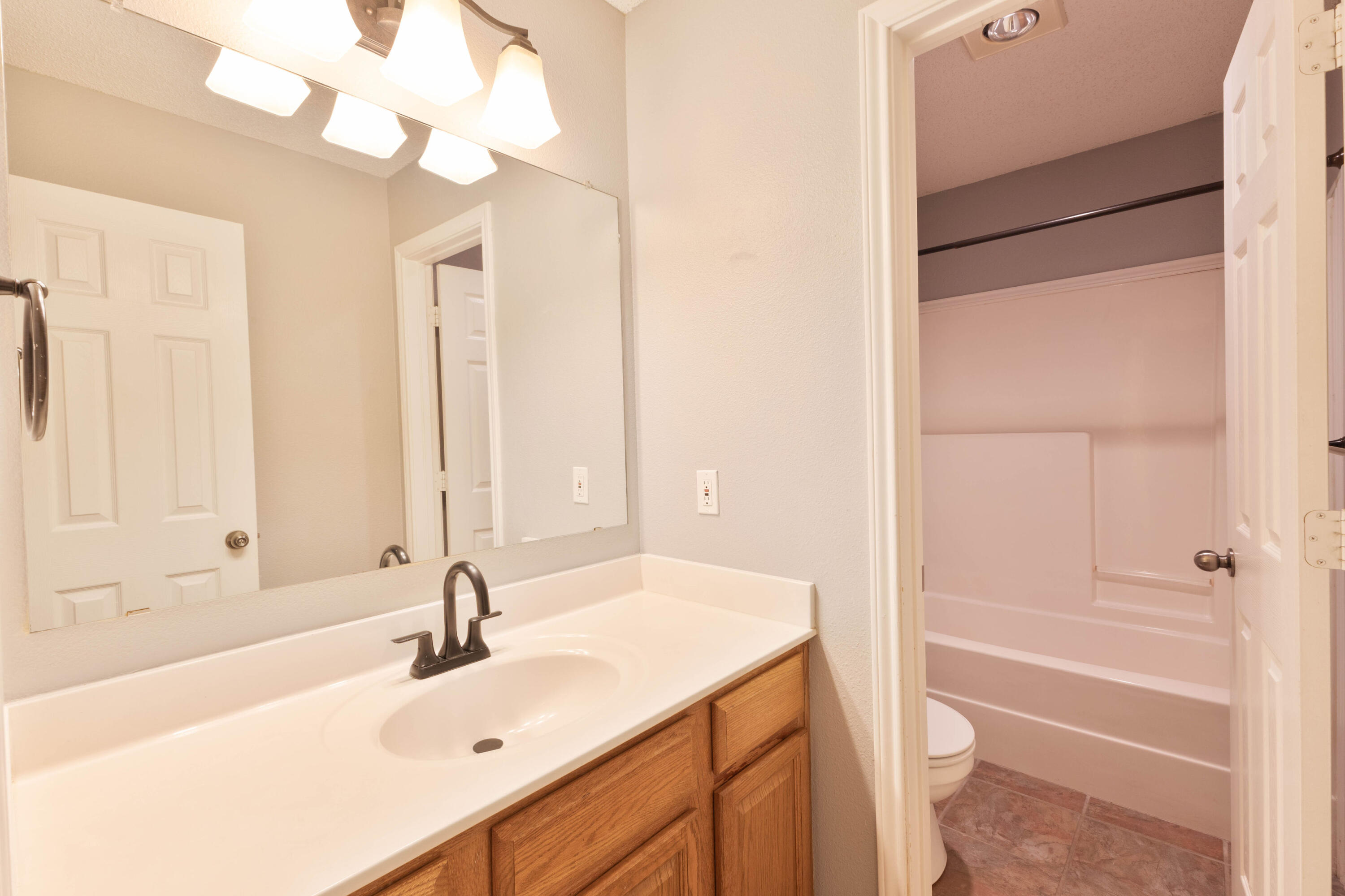5917 88th Place Lubbock, TX 79424 - Photo 12 of 18 a bathroom with a tub sink and a mirror