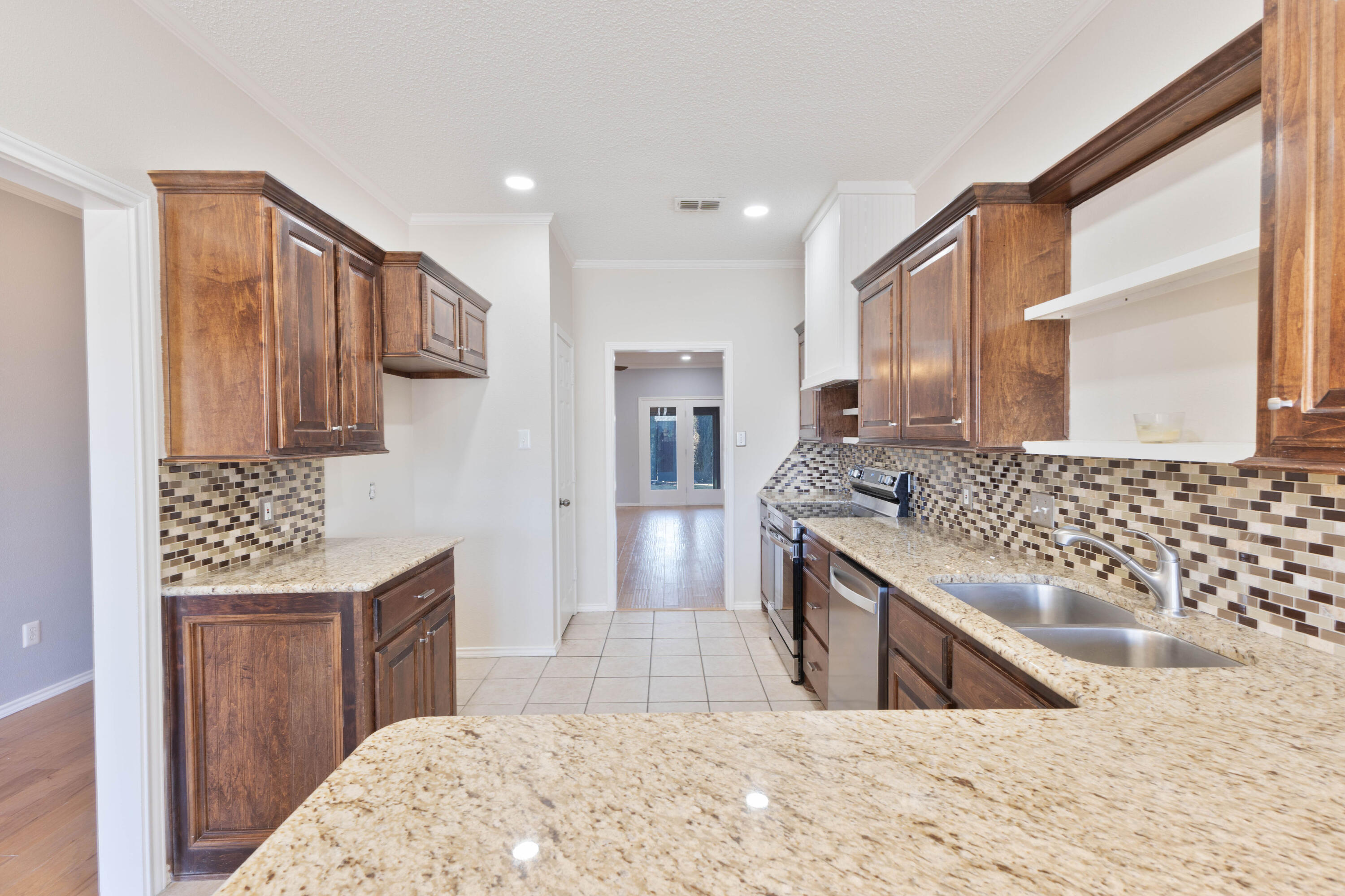5917 88th Place Lubbock, TX 79424 - Photo 3 of 18 a kitchen with stainless steel appliances kitchen island granite countertop a sink and wooden cabinets