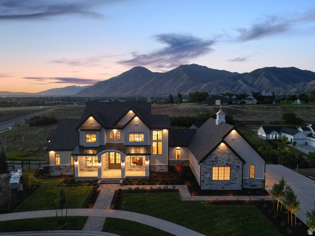 115 East Hidden Ridge Lane, Unit 42 Mapleton, UT 84664 - Photo 95 of 103 Multi-level residence featuring a stone and siding exterior, arched entry, covered porch, dormer windows, and an attached garage with a cupola