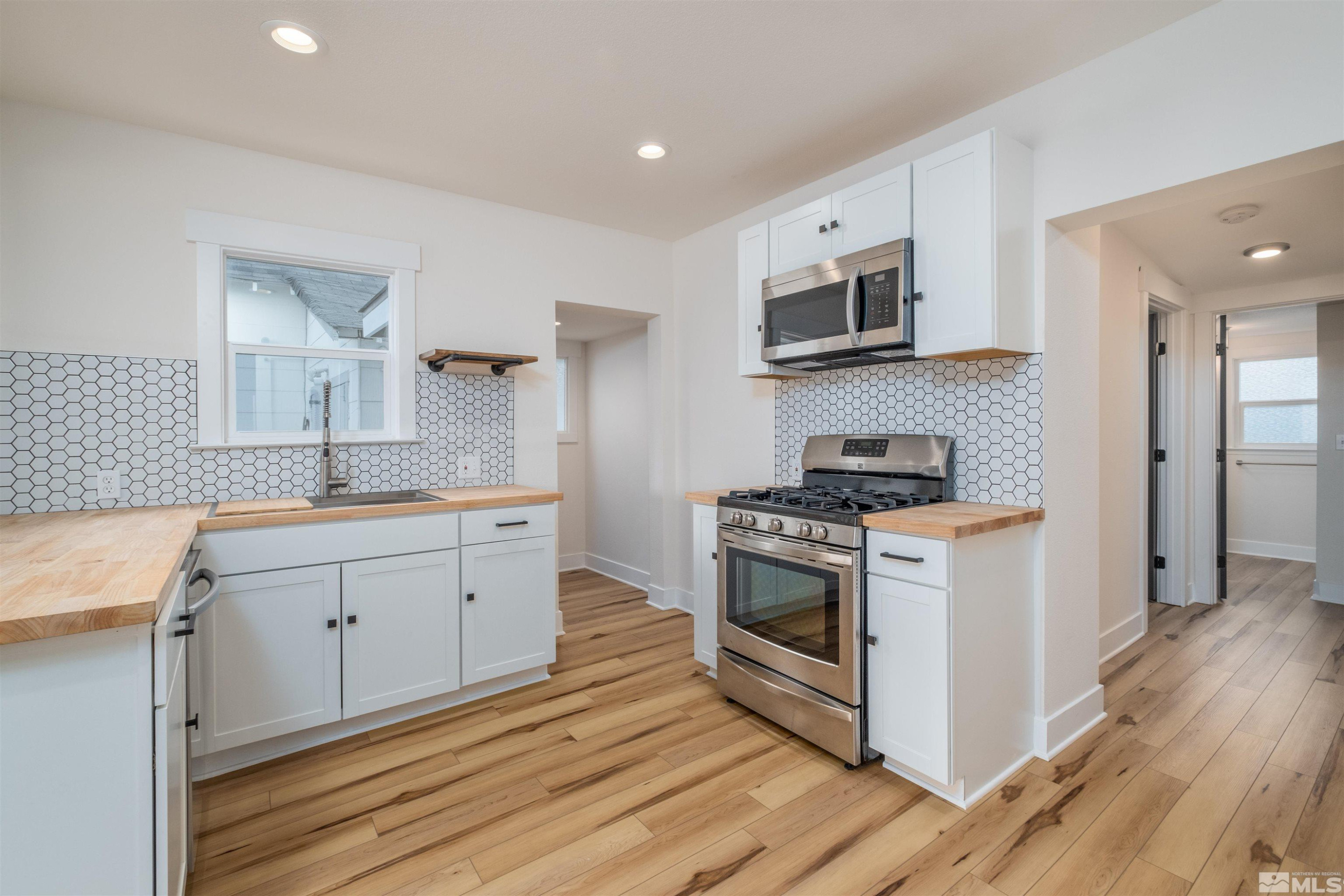 1401 Locust Street Reno, NV 89502 - Photo 14 of 29 a kitchen with stainless steel appliances white cabinets a sink and a stove