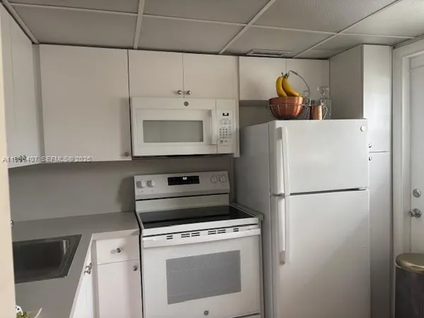 a white refrigerator freezer and a stove sitting inside of a kitchen