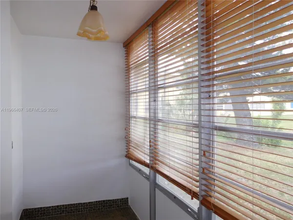 an empty room with a window and a fan