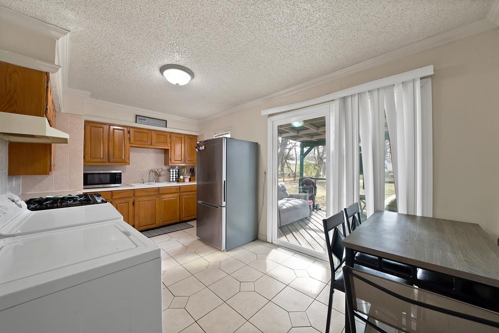 4153 Doyle Lane Lancaster, TX 75134 - Photo 6 of 20 a kitchen that has a microwave a stove and a refrigerator