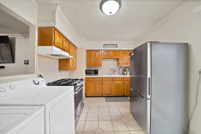 a kitchen with a sink a stove cabinets and a refrigerator