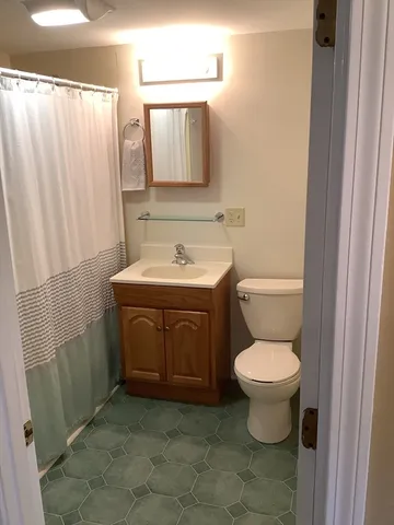 a bathroom with a toilet sink and mirror
