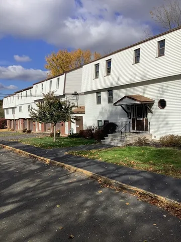 a view of a big house with a big yard and large tree