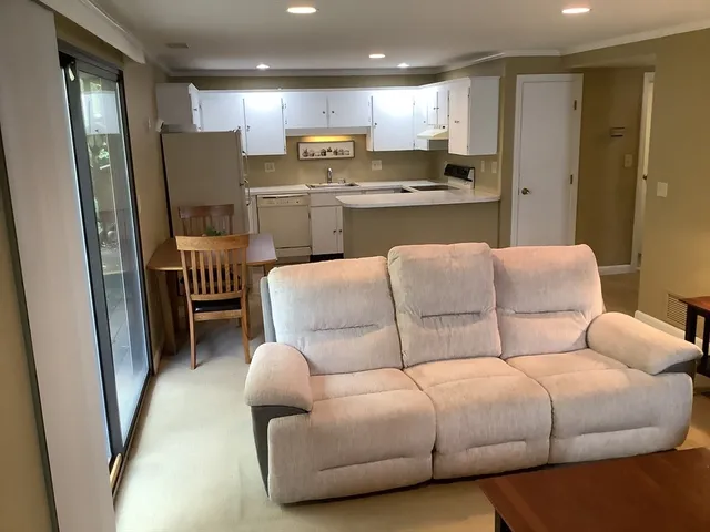 a living room with furniture and a view of kitchen