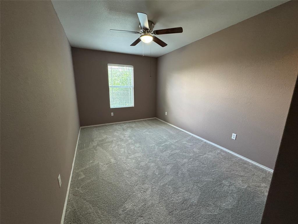 3200 Crownover Street Austin, TX 78725 - Photo 9 of 23 A spacious bedroom featuring soft carpet and a cooling ceiling fan.