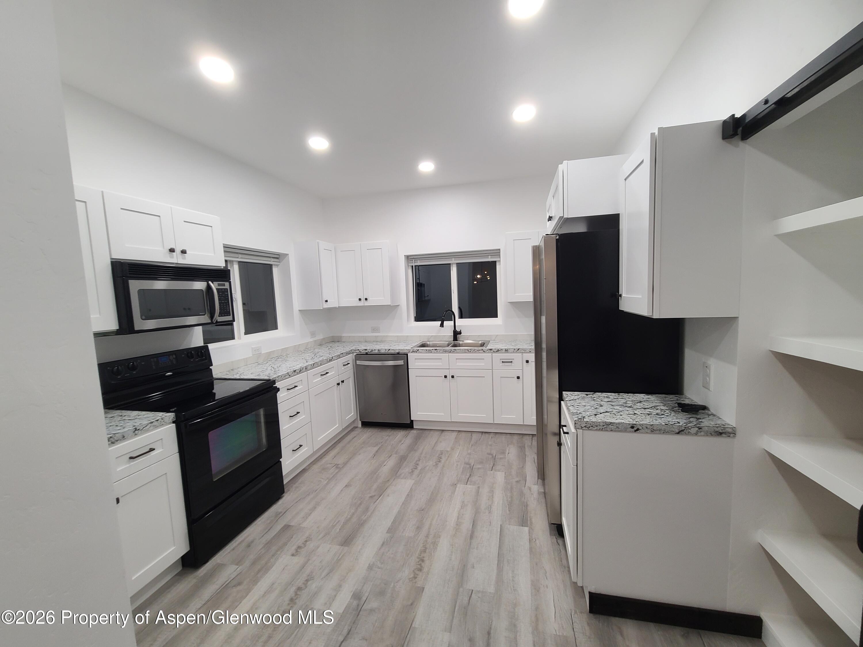 411 County Road 237 Silt, CO 81652 - Photo 40 of 45 a kitchen with a sink a microwave a refrigerator and cabinets