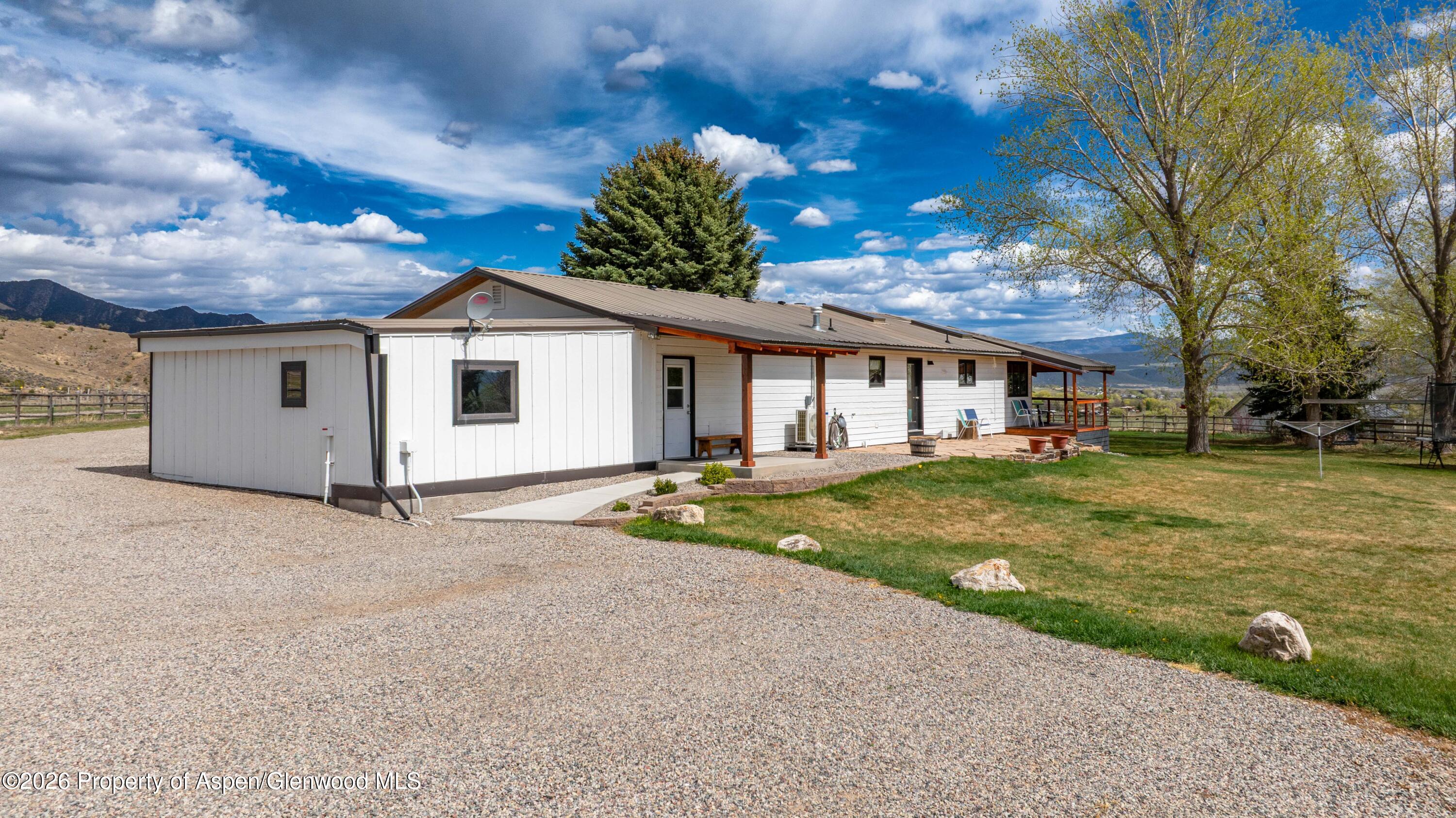 411 County Road 237 Silt, CO 81652 - Photo 5 of 45 a view of a white house with a big yard and large trees