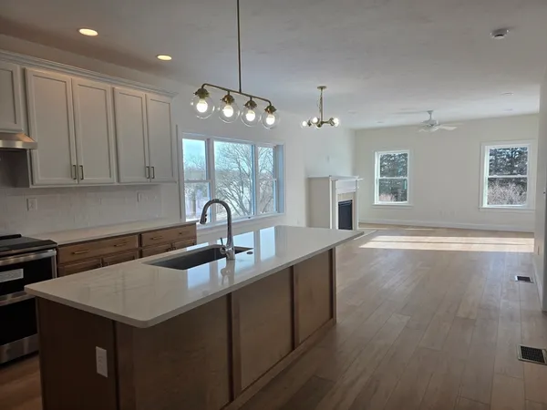 a kitchen with a sink chandelier and wooden floor