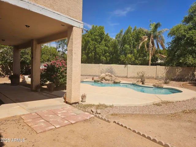 a view of a backyard with table and chairs under an umbrella