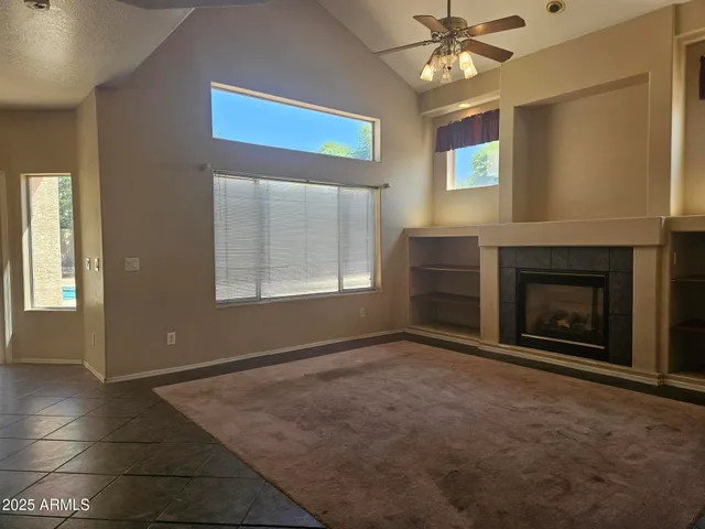 a view of an empty room with a fireplace and a window