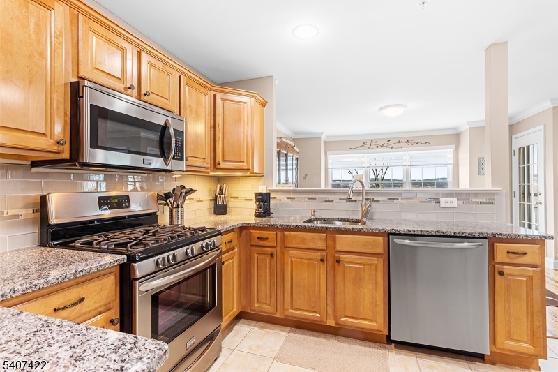 124 Ridge Drive Pompton Lakes, NJ 07442 - Photo 11 of 32 a kitchen with stainless steel appliances granite countertop a stove top oven a sink dishwasher and microwave with wooden floor