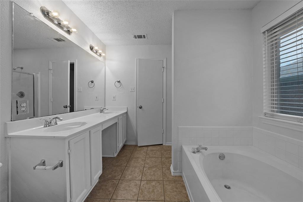 2910 Chisholm Trail Corinth, TX 76210 - Photo 19 of 30 a spacious bathroom with a tub sink shower and mirror