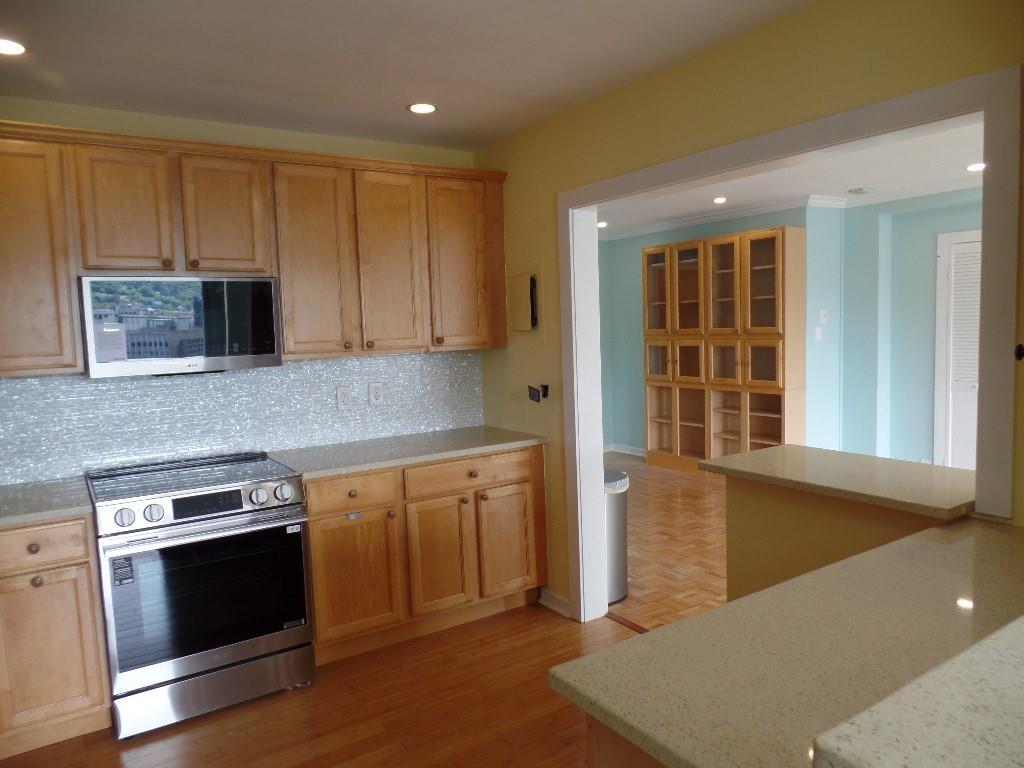 320 Fort Duquesne Boulevard, Unit 24M Pittsburgh, PA 15222 - Photo 12 of 40 a kitchen with stainless steel appliances granite countertop a stove a sink and a microwave