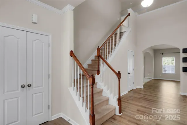 a view of a hallway with wooden floor and staircase